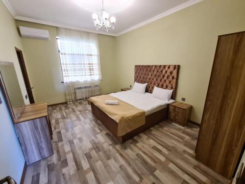 a bedroom with a large bed and a wooden floor at Villa Qebele in Küsnǝt