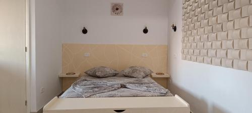 Dar Lebharr Studio في قليبية: سرير صغير في غرفة بجدار من الطوب