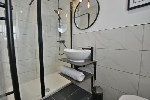 ein Bad mit einem Waschbecken und einem Spiegel in der Unterkunft Quirky cottage set in Clitheroe in Clitheroe