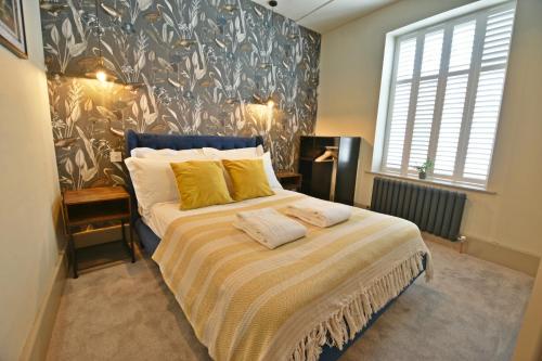 a bedroom with a large bed with yellow pillows at Quirky cottage set in Clitheroe in Clitheroe