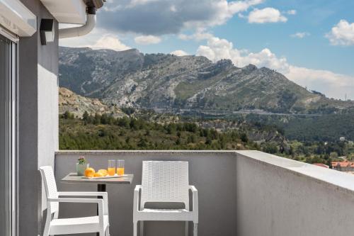 een balkon met een tafel en stoelen en bergen bij Apartments Villa Salona Sky in Solin