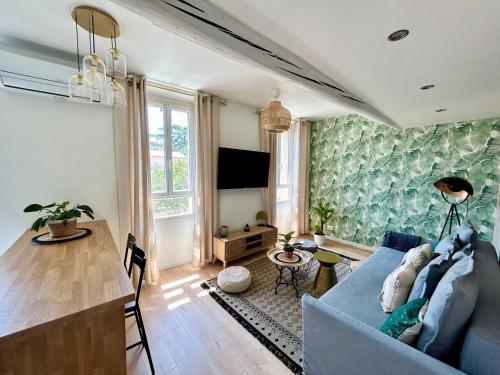 sala de estar con sofá azul y mesa en Rue Marceau Cogolin, en Cogolin