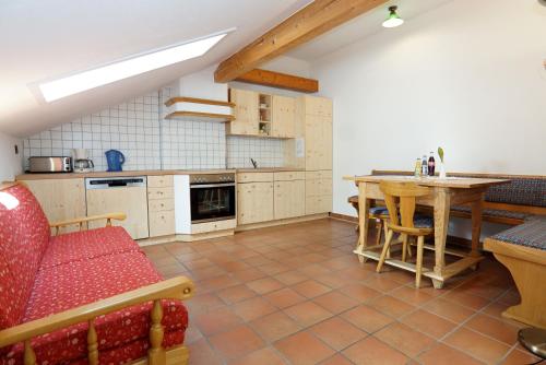 a kitchen with a table and a red couch at Feriengut zum Fürst`n mit Außenwhirlpool und Sauna in Eppenschlag