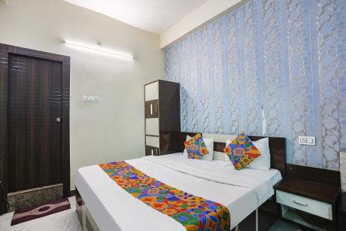 1 dormitorio con cama y pared azul en FabHotel Royal Stay Inn, en Allahābād
