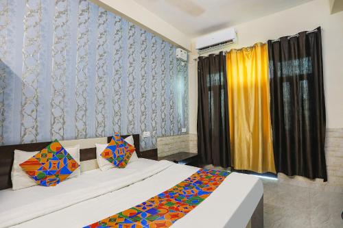 a bedroom with two beds and a window with a curtain at FabHotel Royal Stay Inn in Allahābād