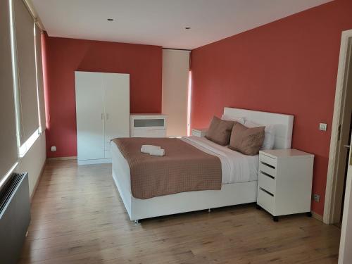 ブリュッセルにあるLes Pieds a La Grande Placeの赤い壁のベッドルーム1室(大型ベッド1台付)
