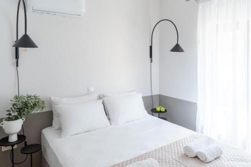 Un dormitorio blanco con una cama blanca con toallas. en Syra Suites, en Vári