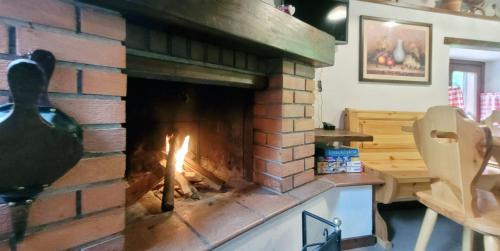 a brick fireplace with a fire in it at Charming Mountain Hut on Grigna Mountain - Como Lake in Pasturo