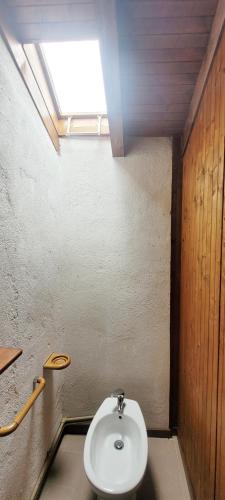 a bathroom with a white toilet in a room at Charming Mountain Hut on Grigna Mountain - Como Lake in Pasturo
