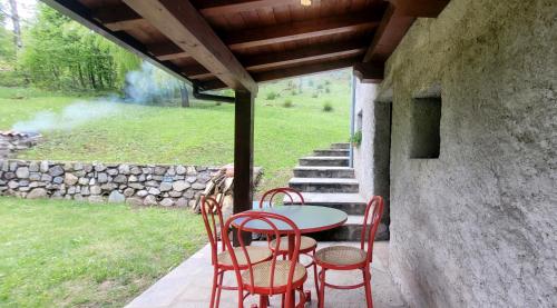 a patio with a table and chairs on a porch at Charming Mountain Hut on Grigna Mountain - Como Lake in Pasturo