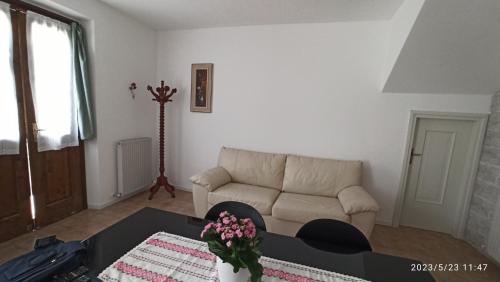 a living room with a couch and a table at Appartamento Taverna Gattolini Venzone in Venzone