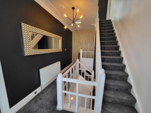 a staircase in a home with black walls and a mirror at St Chads Suites by Central Beach Leisure in Blackpool