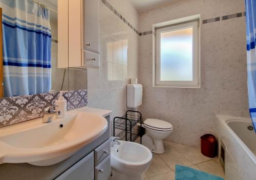 La salle de bains est pourvue d'un lavabo, de toilettes et d'une fenêtre. dans l'établissement Mark, à Novigrad
