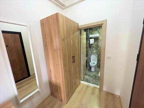 a bathroom with a wooden door and a toilet at ZMF Pansiyon in Istanbul