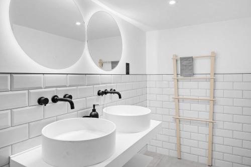 ein weißes Badezimmer mit 2 Waschbecken und einem Spiegel in der Unterkunft Mayflower, Maritime Suites in Brixham
