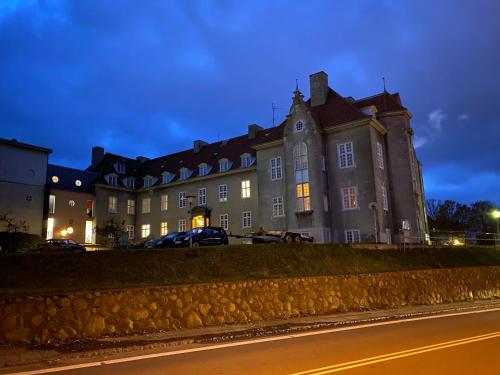 un vieux bâtiment la nuit avec les lumières allumées dans l'établissement Slottets Anneks, à Rønne