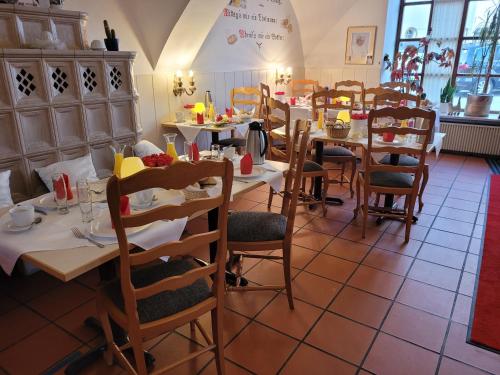 ein Esszimmer mit Tischen und Stühlen in einem Restaurant in der Unterkunft Pension Benedikt in Aschau am Inn