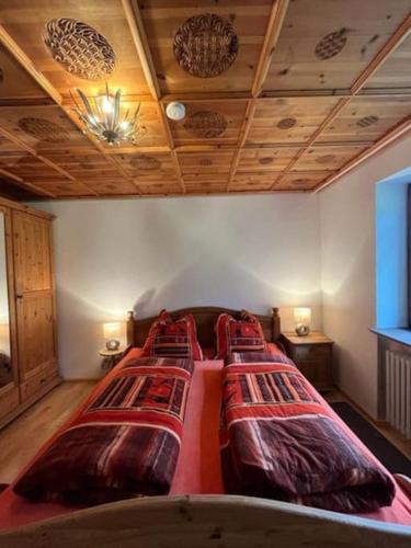 a bedroom with four beds in a room with wooden ceilings at Schnitzer-Stüble in Missen-Wilhams