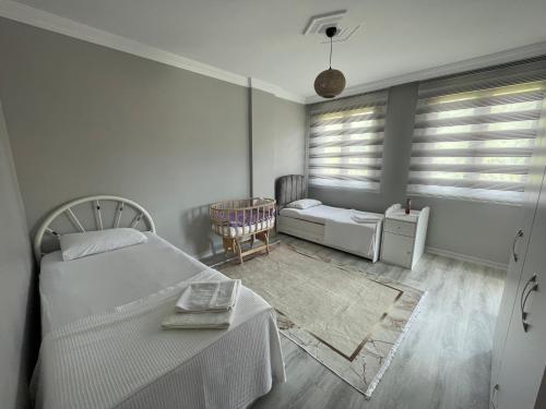 a bedroom with a bed and a table and a chair at Greenland Villa Premium 61 in Trabzon