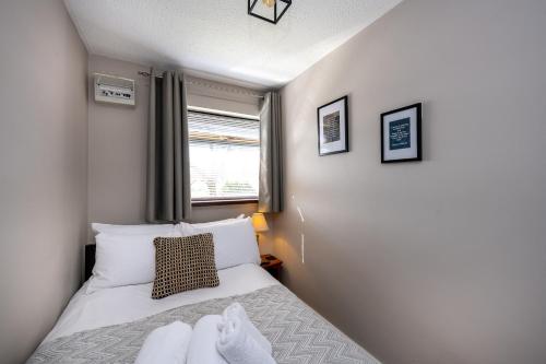 a small bedroom with a bed and a window at Charming 2-Bed Home in Neath in Skewen