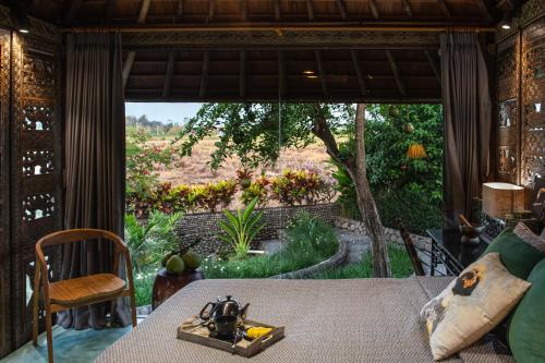 a room with a table with a view of a garden at Beachfront Villa Pryaniki Tabanan in Tabanan