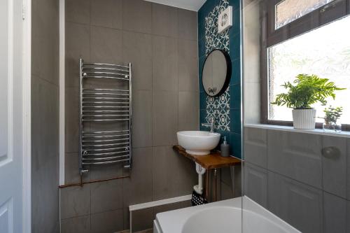 a bathroom with a sink and a mirror at Charming 2-Bed Home in Neath in Skewen