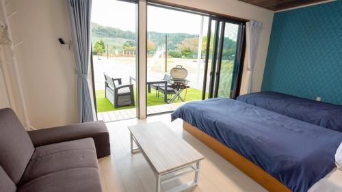 1 dormitorio con cama, sofá y mesa en Ｎasu Utopia Minosawa Art Village en Nasu