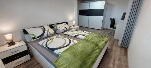 a bedroom with a large bed and a desk at Gemütliche Ferienwohnung am Schwarzwaldrand in Jettingen