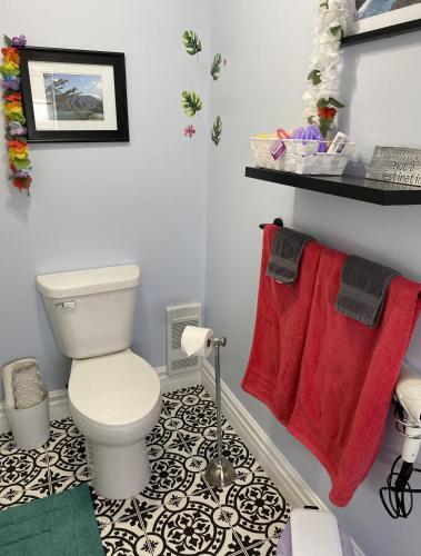a bathroom with a toilet and red towels at Seabank House Bed and Breakfast Aloha in Pictou