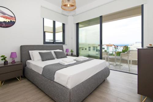 een slaapkamer met een groot bed en een balkon bij Villa Amity in Protaras