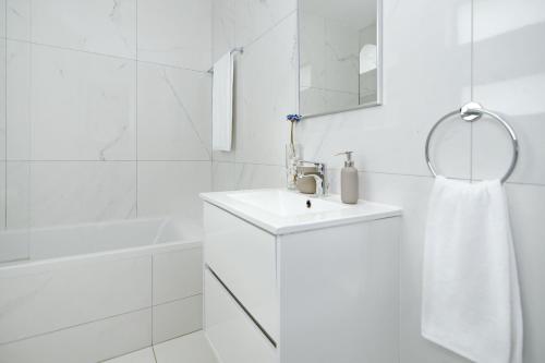 een witte badkamer met een wastafel en een spiegel bij Villa Amity in Protaras
