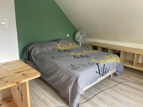 une chambre avec un lit et une table dedans dans l'établissement Maison Mimosa, à Saumur