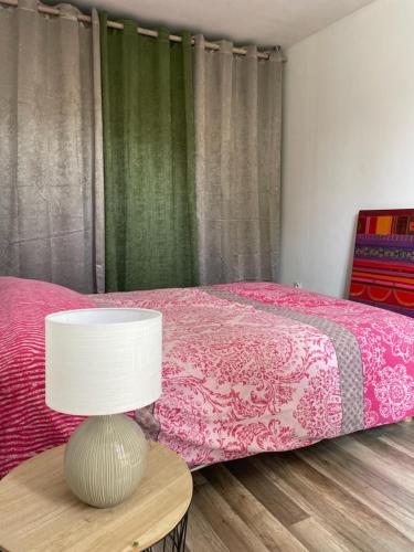 une chambre avec un lit et une table avec une lampe dans l'établissement Maison Mimosa, à Saumur