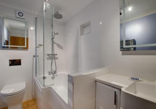 een badkamer met een douche, een toilet en een wastafel bij Flat 3 Durlston Court in Swanage