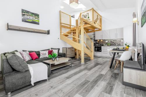 a living room with a couch and a staircase at KORZO Lipno in Lipno nad Vltavou