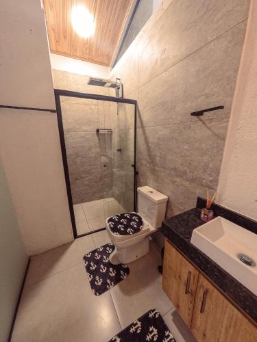 a bathroom with a shower and a toilet and a sink at Chalé de Piri in Pirenópolis