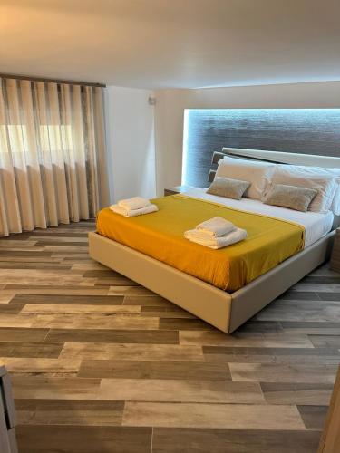 a bedroom with a large bed and a wooden floor at Sanduli Luxury House in Agrigento