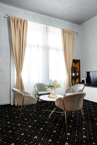 a living room with chairs and a table and a window at Palace Bulevard Inn in Cluj-Napoca