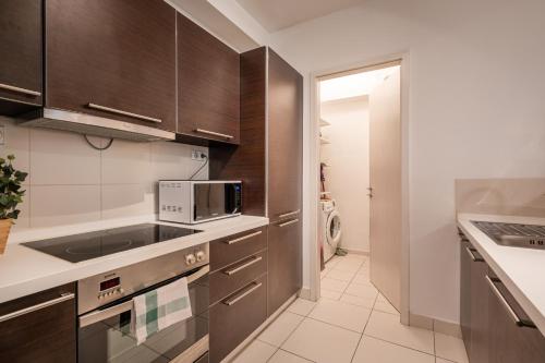 a kitchen with brown cabinets and a microwave at Paulay Private Apartment in Budapest