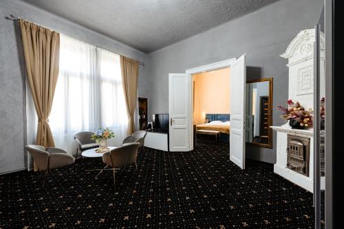 a hotel room with a bed and a table and chairs at Palace Bulevard Inn in Cluj-Napoca