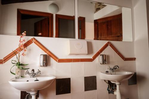 La salle de bains est pourvue de 2 lavabos et d'un miroir. dans l'établissement CASA RURAL La Moranta, à Herguijuela