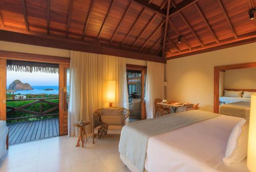 a bedroom with a bed and a view of the ocean at NANNAI Noronha Solar Dos Ventos in Fernando de Noronha