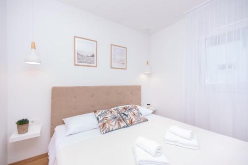 a white bedroom with a large white bed with white pillows at Flying Bridge in Podstrana