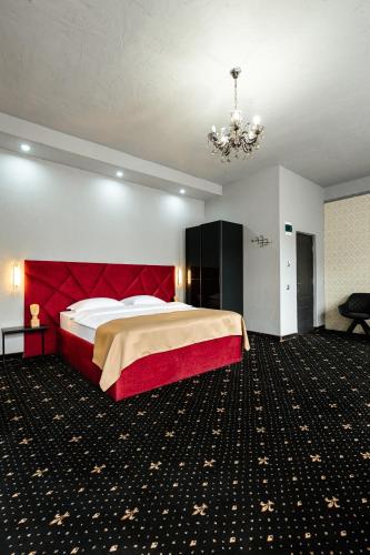 a large bedroom with a large bed and a chandelier at Palace Bulevard Inn in Cluj-Napoca