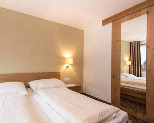 a bedroom with two beds and a large mirror at Haus Gant in Sankt Gallenkirch