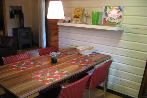 a dining room table with red chairs and a wooden table at Holzhaus am Heidesee in Müden