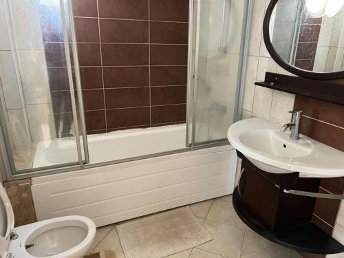 ein Bad mit einer Dusche, einem WC und einem Waschbecken in der Unterkunft SunSet Apartments 4,5,6 in Belek