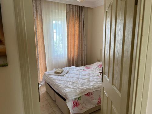 ein kleines Bett in einem Zimmer mit Fenster in der Unterkunft SunSet Apartments 4,5,6 in Belek
