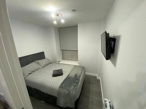 um pequeno quarto com uma cama e uma televisão em Modern Apartment - Wick Harbour em Wick