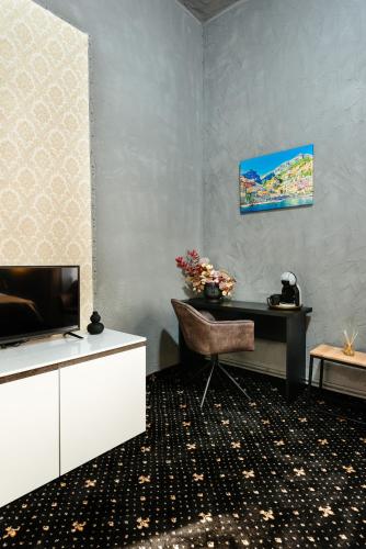 a living room with a desk and a television at Palace Bulevard Inn in Cluj-Napoca
